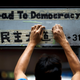 A worker removes masking tape left on a road sign by protesters during the clearance at the last Occupy protest site in Causeway Bay.